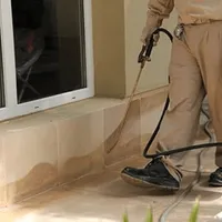General pest control technician spraying exterior perimeter around a home in El Paso, TX